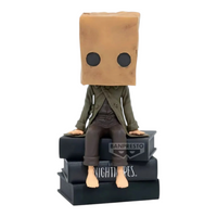 Figurine Mono Monitor Top Figure Vol. 2 – Little Nightmares II, assis sur une pile de livres noirs.
