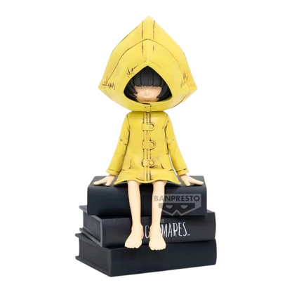 Figurine Six Monitor Top Figure Vol. 1 – Little Nightmares, assise sur une pile de livres noirs avec son imperméable jaune.